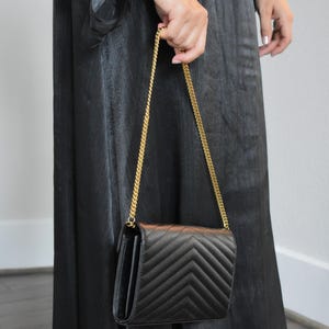 a woman in a black dress holding a black purse