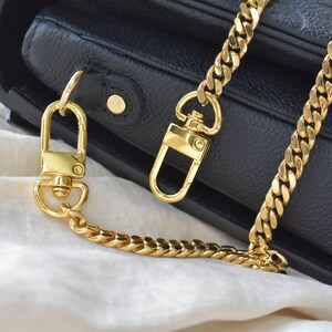 a black purse with a gold chain attached to it