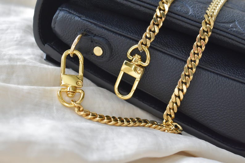 a black purse with a gold chain attached to it
