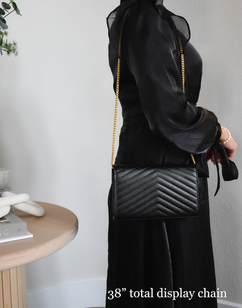 a woman in a black dress holding a black purse