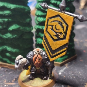 May include: A miniature figure of a dwarf holding a flag with a yellow and black design. The flag has a stylized eye with a crescent moon inside. The dwarf is wearing black armor and has a long red beard.