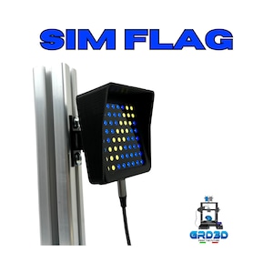 Può includere: Un dispositivo nero stampato in 3D con una griglia di luci gialle e blu. Il dispositivo è montato su un palo argentato ed è etichettato "SIM FLAG".
