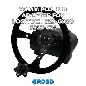Puede incluir: Un adaptador de volante negro para volantes de carreras Logitech G29, G920, G923 y G27. El adaptador tiene un cubo PCD de 70 mm y está hecho de plástico y metal negros. El adaptador se muestra montado en un volante.