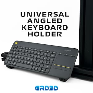 May include: A dark gray Logitech keyboard with a built-in touchpad and yellow accents. The keyboard is angled and mounted on a black holder. Text on the image reads "UNIVERSAL ANGLED KEYBOARD HOLDER" and "GRD3D".