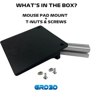 May include: A black plastic mouse pad mount with two screws and two T-nuts. The mount is designed to attach to a metal track system. The text "WHAT'S IN THE BOX?" is at the top of the image. The text "MOUSE PAD MOUNT + T-NUTS & SCREWS" is below the image. The text "GRD3D" is at the bottom of the image.