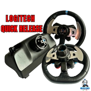 Könnte beinhalten: Ein Logitech Schnellverschluss-Lenkradadapter mit schwarzer Basis und einem silbernen und schwarzen Lenkrad. Der Adapter hat einen blauen Knopf und das Lenkrad hat einen blauen Streifen.