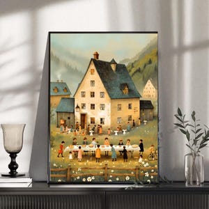 Peut inclure: Une impression encadrée représentant une scène de village pittoresque avec un grand bâtiment comme point central. Des personnes se réunissent autour d'une longue table dressée pour un repas. L'œuvre présente une palette de couleurs sourdes avec un cadre pastoral.