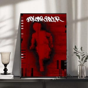 Könnte beinhalten: Ein gerahmter Kunstdruck mit einem abstrakten roten und schwarzen Design. Das Kunstwerk zeigt eine Silhouette einer rennenden Figur mit dem Text "PSYCHO SHADER" in weißer, stilisierter Schrift oben. Der Druck wird auf einem schwarzen Schrank ausgestellt.