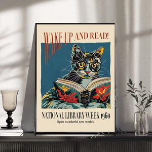 Könnte beinhalten: Gerahmtes Poster mit einer Vintage-Illustration einer Katze mit Brille, die ein Buch liest. Das Poster trägt den Text "WAKE UP AND READ!" und "NATIONAL LIBRARY WEEK 1960". Die Katze ist in Gelb, Grün und Schwarz dargestellt.