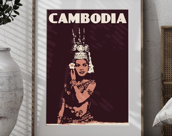 May include: Framed art print featuring a stylized illustration of a Cambodian dancer. The artwork is in shades of brown, beige, and burgundy, with the word "CAMBODIA" at the top. The dancer is adorned with traditional headdress and attire.