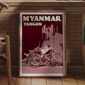 Peut inclure: Affiche encadrée de voyage avec les mots "MYANMAR YANGON". L'illustration présente une personne allongée sur un vélo, dans des tons bordeaux et rose, de style vintage.