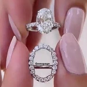 May include: A silver engagement ring with a large oval-shaped diamond center stone and a halo of smaller diamonds. The ring is set on a white gold band. The text "Gemspace" is visible on the ring.