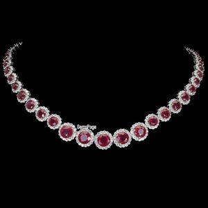 以下が含まれることがあります： 繊細なデザインのルビーとダイヤモンドのネックレス。ネックレスは、白い金属にセットされた丸い赤いルビーの列を特徴とし、各ルビーの周りを小さなダイヤモンドが囲んでいます。