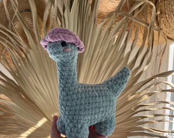 Crocheted small dinosaur with hat, soft amigurumi cuddly toy