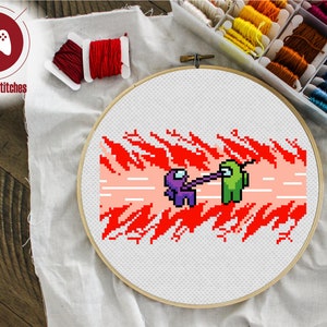 May include: Cross-stitch embroidery of two Among Us characters, one purple and one green, in a red and pink flame design. The characters are holding hands and the background is a red and pink flame design.