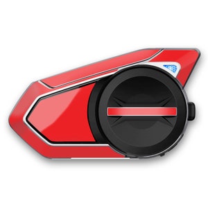 May include: A red motorcycle communication device with a black speaker and a silver trim. The device has a red button on the side.