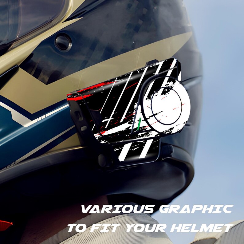 May include: A black and white graphic device with red accents is attached to a motorcycle helmet. The device has a circular component with a target design. The text "VARIOUS GRAPHIC TO FIT YOUR HELMET" is visible at the bottom.