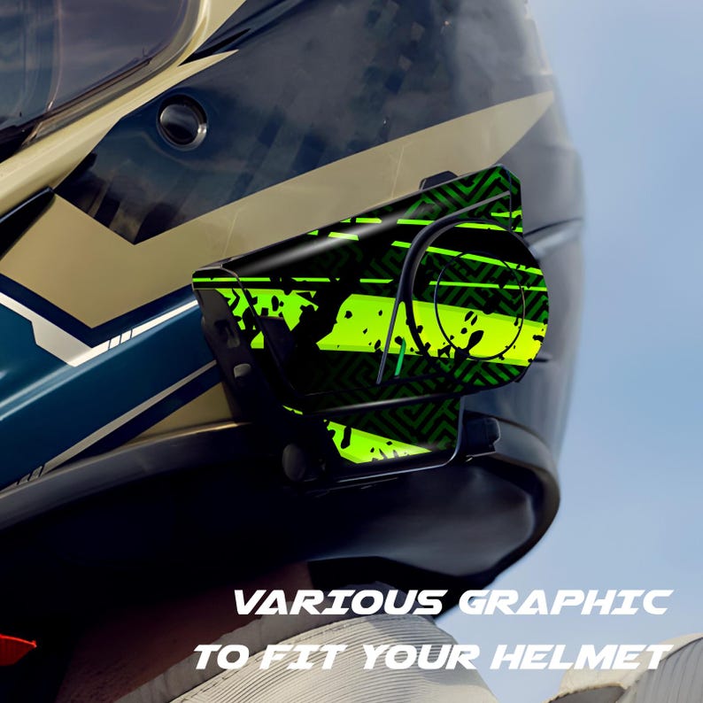 May include: A black motorcycle helmet with a mounted accessory featuring a vibrant green and black graphic design. The accessory is attached to the side of the helmet. Text at the bottom reads "VARIOUS GRAPHIC TO FIT YOUR HELMET."