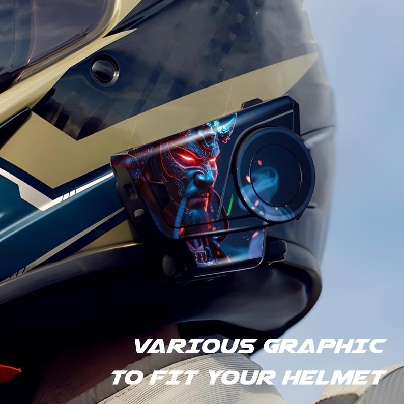 May include: A black motorcycle helmet with a graphic of a blue and red demon face. The helmet has a camera attached with a circular lens. The text "VARIOUS GRAPHIC TO FIT YOUR HELMET" is at the bottom.