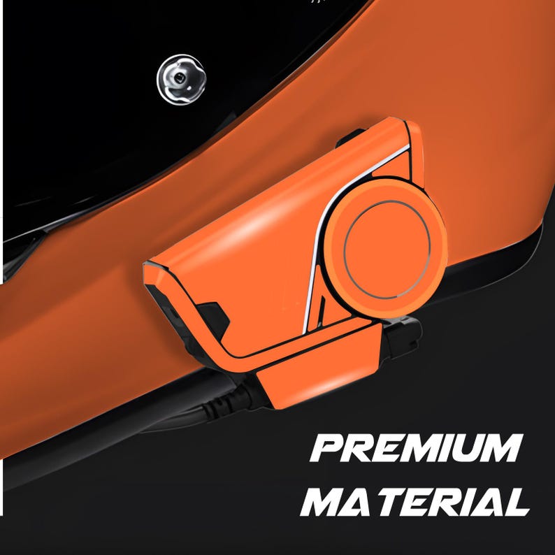 May include: Close-up of an orange device with a circular component and black accents. The text "PREMIUM MATERIAL" is displayed in white. The device is set against a black background.