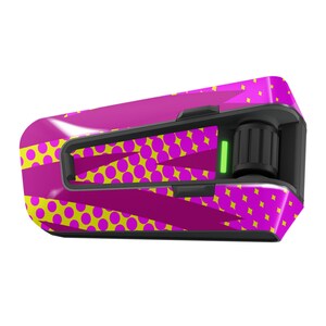 May include: A pink and yellow patterned motorcycle helmet communication device with a black control knob and a green light.