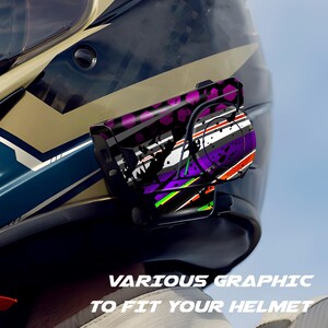 Pu&ograve; includere: Casco da moto nero con un design grafico con accenti viola, bianchi e neri. Il casco ha un dispositivo di comunicazione attaccato con un design abbinato. Il testo "VARIOUS GRAPHIC TO FIT YOUR HELMET" &egrave; visibile.