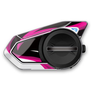 May include: A black and white motorcycle helmet communication device with a pink and white abstract design. The device has a round, black speaker and a silver trim.