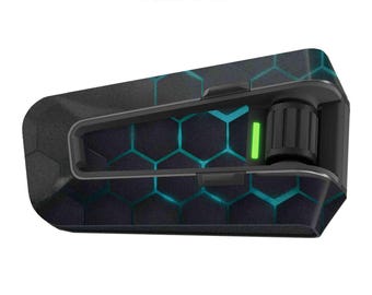 May include: A black and teal communication device with a hexagonal pattern and a green light. The word "Matte" is written in teal script at the top. The device has a dial and a rectangular shape.