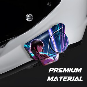 May include: A white and black object with a graphic of an anime character and a futuristic background. The graphic is on a curved surface. The text "PREMIUM MATERIAL" is displayed in white letters.