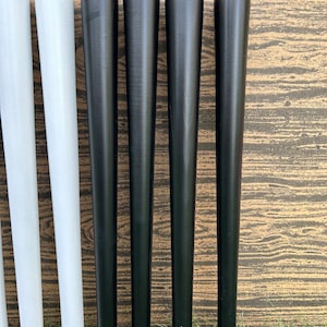 May include: Six wooden furniture legs, four black and two white, arranged in a row. The legs are tapered and have a smooth finish.