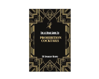 May include: A black book with a gold art deco design on the cover. The title is "The At Home Guide To Prohibition Cocktails" with the subtitle "36 Speakeasy Recipes".