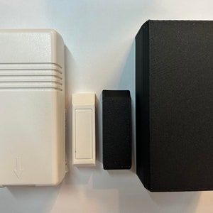 以下が含まれることがあります： 下向きに黒い矢印が付いた白いセキュリティセンサー、白い長方形のセンサーと黒い長方形のセンサー、黒い長方形の箱