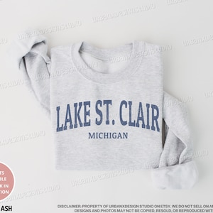 May include: A gray sweatshirt with the text "LAKE ST. CLAIR MICHIGAN" printed in blue.