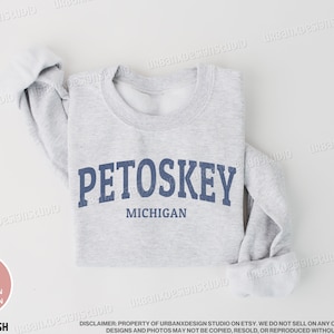 May include: A gray sweatshirt with the text "PETOSKEY MICHIGAN" printed in blue on the front.