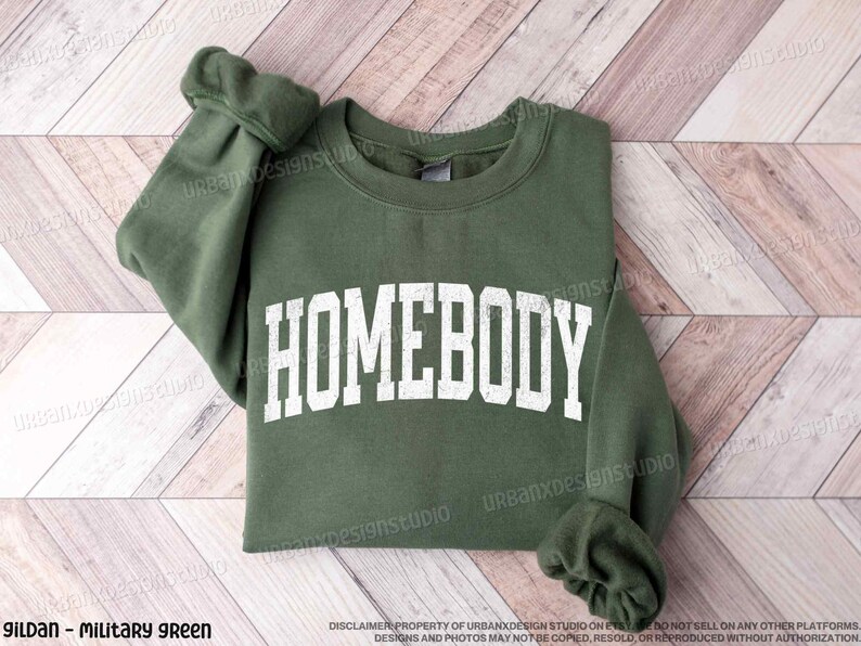 May include: A green sweatshirt with the word "HOMEBODY" printed in white on the front.