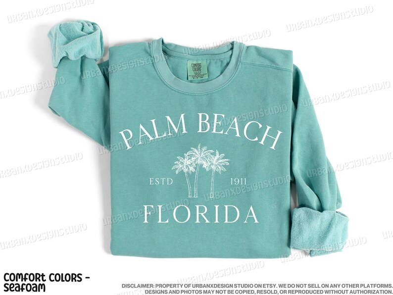 May include: Seafoam green sweatshirt with a white graphic print of palm trees and the text "PALM BEACH ESTD 1911 FLORIDA".
