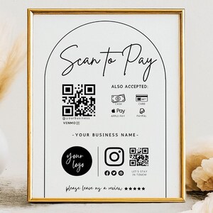May include: A white sign with a gold frame, featuring a black and white QR code, the text "Scan to Pay", and the words "Also Accepted: Cash, Card, Apple Pay, Paypal, Venmo". The sign also includes a black circle with the text "Your Logo" and a black Instagram icon with a QR code.