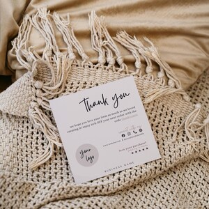 Op de afbeelding: Een bedankkaart met een eenvoudig ontwerp. De kaart heeft een cirkel met de tekst "your logo" in de linkerbenedenhoek. De tekst "Thank you" is in cursief bovenaan de kaart geschreven. De kaart bevat ook de tekst "we hope you love your item as much as we loved creating it! enjoy 20% OFF your next order with the code thankyouz".