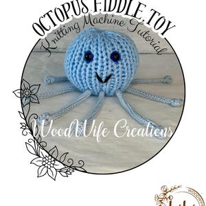 May include: A light blue knitted octopus toy with button eyes and a smiling face. The text "OCTOPUS FIDDLE TOY Knitting Machine Tutorial" is in a circular design. The brand name "Wood Wife Creations" is also visible.