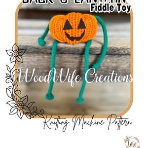 May include: An orange knitted Jack-O-Lantern fiddle toy with a black smiling face and green legs. The text "Jack-O-Lantern Fiddle Toy" is at the top, and "Wood Wife Creations" and "Knitting Machine Pattern" are also visible.