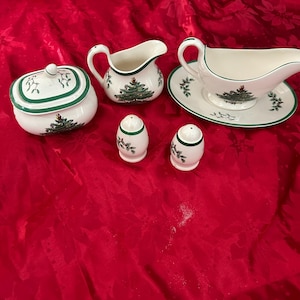 May include: A Spode Christmas Tree pattern serving set. The set includes a sugar bowl, creamer, gravy boat with saucer, and two salt and pepper shakers. Each piece is white with a green trim and a Christmas tree design.
