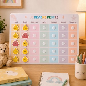 Peut inclure: Un tableau de suivi des tâches coloré avec le texte "JE DEVIENS PROPRE" et les jours de la semaine. Le tableau comporte des cases pour suivre les tâches, avec des autocollants de gouttes jaunes souriantes et un emoji caca souriant. Un ours en peluche, des livres et un carnet sont également visibles.