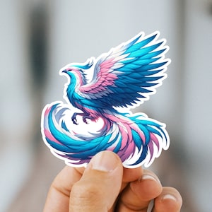 May include: A sticker of a blue, pink, and white phoenix with its wings spread wide. The phoenix is a symbol of rebirth and hope.