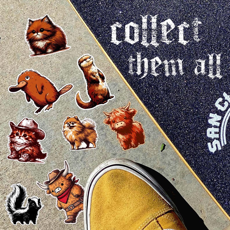 May include: A collection of animal stickers, including a cat, a platypus, a skunk, and a highland cow, are displayed on a concrete surface next to a skateboard. The skateboard has the text "collect them all" in white lettering. A yellow shoe is in the foreground.