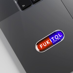 Funny FUKITOL pill-shaped sticker on laptop