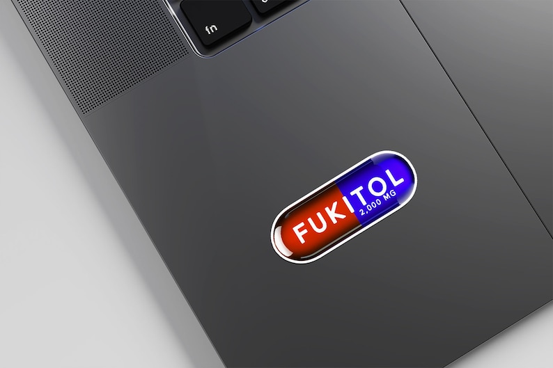 Funny FUKITOL pill-shaped sticker on laptop