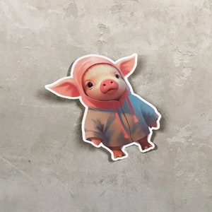 May include: A pink pig wearing a light blue hooded sweatshirt with a pink hood. The pig is looking at the camera.