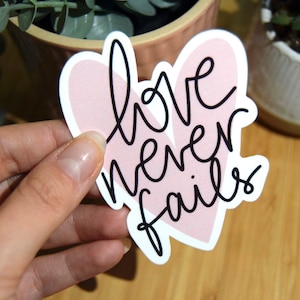 Grand sticker "Love never fails" - sticker unitaire blanc brillant, ordinateur, tout support, happy stickers