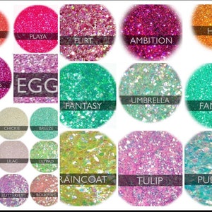 Op de afbeelding: Een verzameling van 20 kleine potjes gevuld met kleurrijke glitter. Elk potje heeft een andere kleur en een naam op het etiket. De namen zijn "Fuego", "Playa", "Flirt", "Ambition", "Hola", "Lip Gloss", "Egg", "Fantasy", "Umbrella", "That's Mint", "Chickie", "Breeze", "Bunny", "Lilac", "Lilypad", "Raincoat", "Tulip", "Puddles", "Bloom", "Butterfly" en "Bouquet".