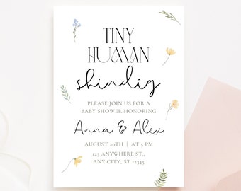 May include: A white baby shower invitation with a floral design. The text reads "Tiny Human Shindig" and "Please join us for a baby shower honoring Anna & Alex". The date and time of the shower are listed as "August 20th | At 5 PM". The address is "123 Anywhere St., Any City, ST 12345".